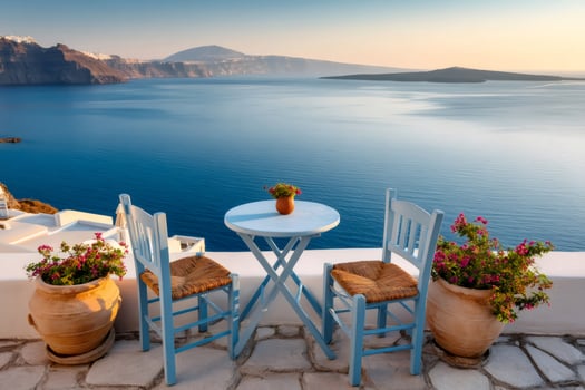 Two chairs and table overlooking picturesque santorini caldera at sunrise photo