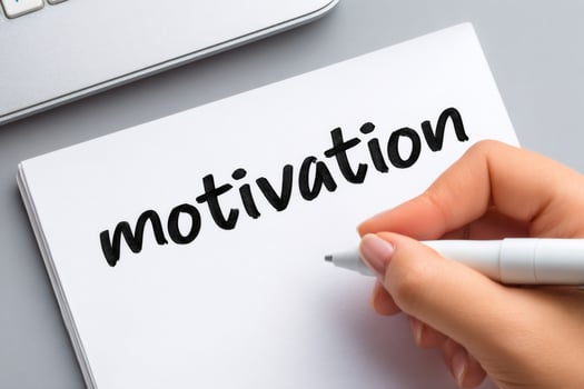 Woman writing motivation on a notepad with a marker pen photo