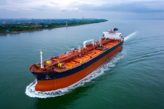 Aerial view of oil tanker ship sailing near coastline on cloudy day photo