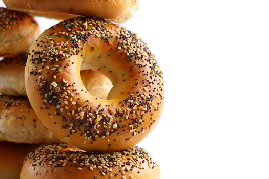 Freshly baked bagels with seed topping stacked on a white background photo