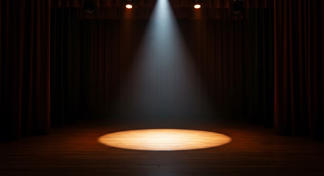 A spotlight shines on a stage with curtains photo