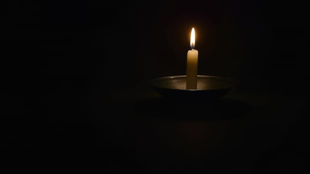 Single Candle Burning In Dark Room photo