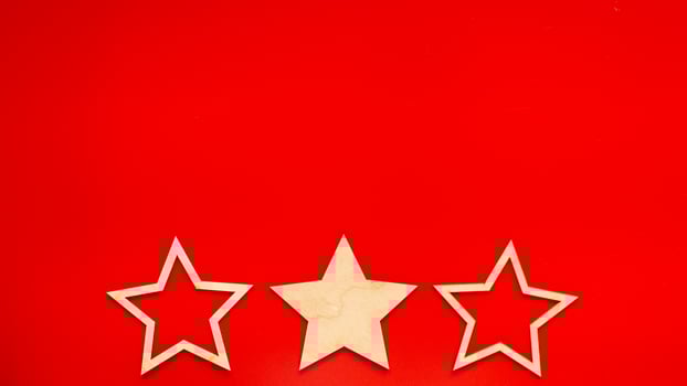 Wide banner Red background with three wooden stars at the bottom in a row photo