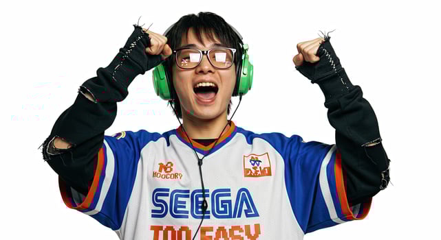 Excited Asian gamer celebrates victory with green headphones and jersey photo