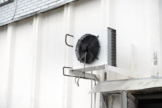 Industrial air conditioning unit mounted on white wall. Temperature control. photo
