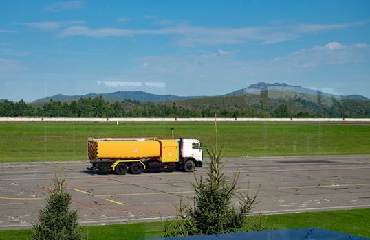 Airplane refueling at airport with mountain backdrop. photo