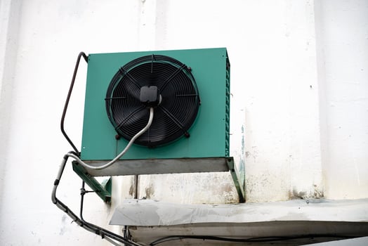 Industrial air conditioning unit mounted on white wall. photo