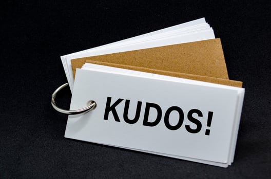 KUDOS text on white notepad. A Simple Gesture, A Powerful Message of Recognition and Encouragement. photo