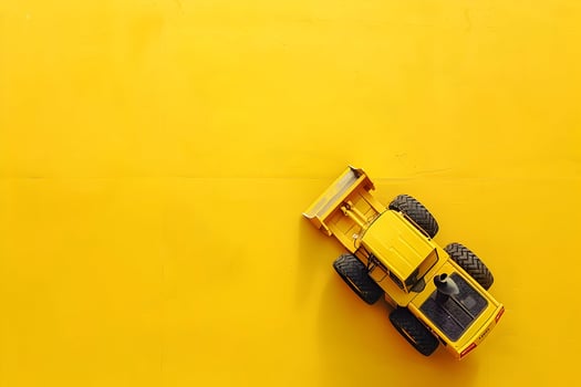 A toy bulldozer on a yellow background photo