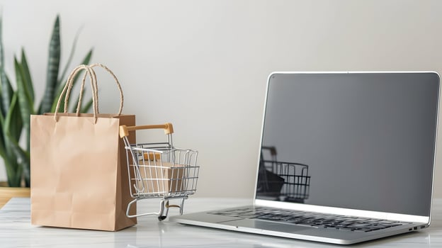 Shopping cart and laptop on table photo