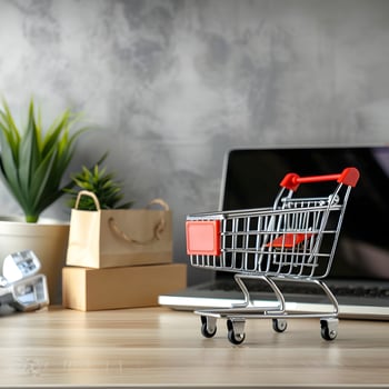 A shopping cart is sitting on a desk next to a laptop photo