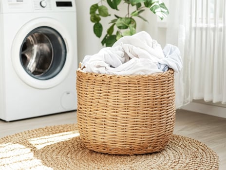 Laundry basket filled with clean clothes in a cozy room photo