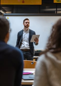 Teacher teaching a class with whiteboard and students taking notes photo