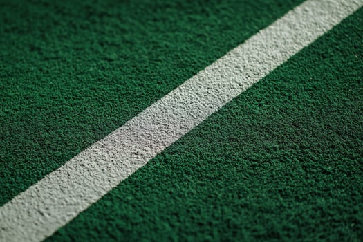 White boundary line on green artificial football pitch, with clear texture details and rich natural lighting photo