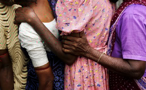 Women Supporting Each Other While Queuing for Aid in a Refugee Camp photo