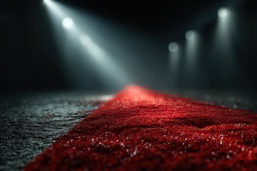 Shimmering red carpet leading to spotlight in a dimly lit venue during an evening event photo