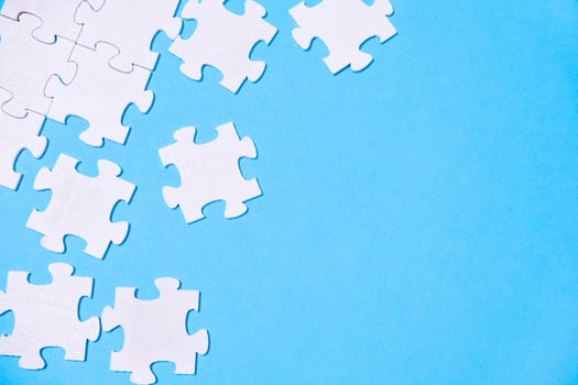 Blue background with white puzzle pieces scattered across it. photo