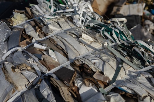 Compacted waste materials are securely bound with straps at a landfill site, highlighting the challenges of pollution and waste management photo