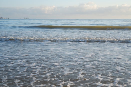 Ocean waves crashing on the shore at sunrise photo
