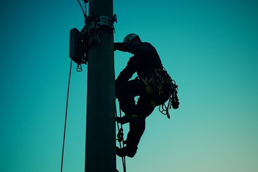Technician climbing utility pole installing telecommunication equipment photo