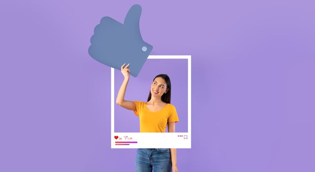 A young woman in a casual yellow shirt smiles brightly while posing with a large thumbs-up graphic. photo