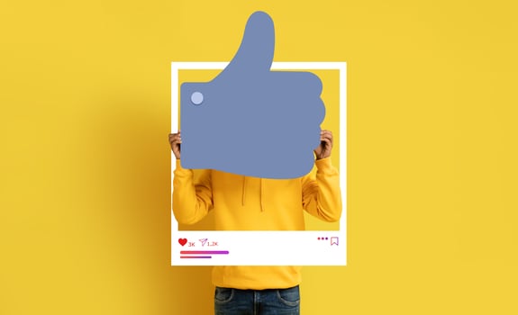 A social media influencer holds up a large thumbs-up symbol against a vibrant yellow background. They promote positivity and engagement in online content, encouraging their followers. photo