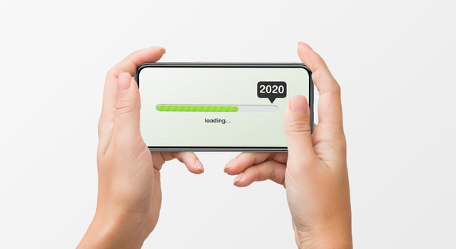 Woman's hands holding smartphone with 2020 number, loading progress bar on white background. 2020 coming soon concept photo