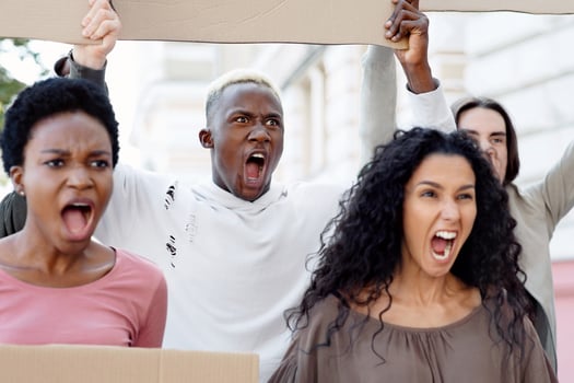 Furious demonstrators making strike against racism, pollution, war. International group of activists young men and women holding empty banners and chanting slogans on the street, closeup photo
