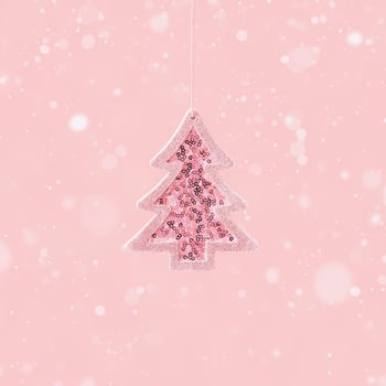 Minimal Christmas and New Year greeting card with pink toy Christmas tree with shiny sequins on pink photo