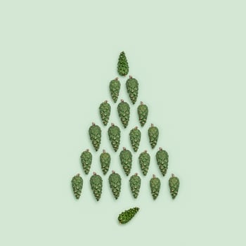 Fir tree from natural green pine cones on pastel green paper, minimal style. Christmas and New Year Holiday symbol photo