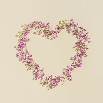 Small pink flowes on beige color. Narural frame in shape of heart. Minimal style aesthetic card for wedding invitation photo