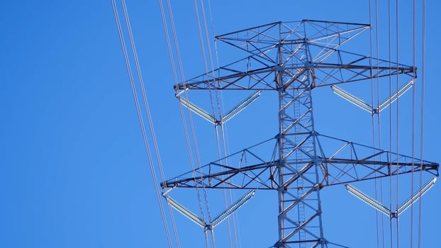 High Voltage Transmission Tower Against Clear Blue Sky on a Sunny Day Capturing Modern Energy Infrastructure photo