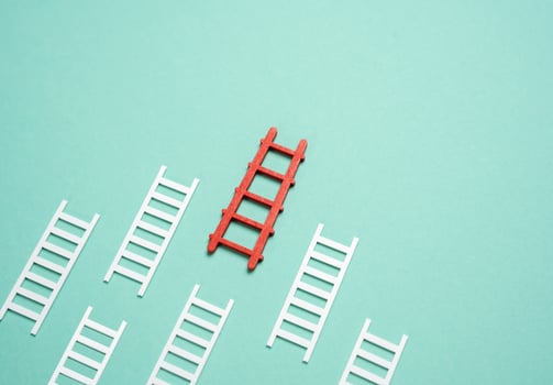 Red ladder first among all white ones. The best plan. Ladders of success. Excellence, career growth, smart choices, and achievement in a competitive environment. photo