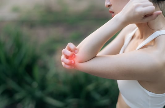Southeast asian female teen experiencing pain during exercise while jogging running in public park, highlighting sport health concerns and discomfort in elbow area, pain in exercise concept. photo