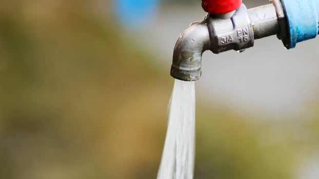 A close up of a water tap with a red handle photo