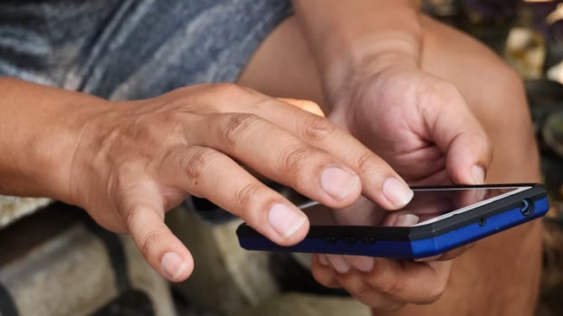 A man holding a cell phone with his hands photo