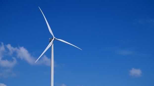 A wind turbine is shown in the sky photo