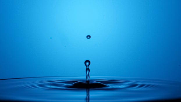 A drop of water is falling into the water photo