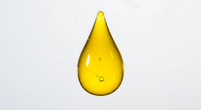 A drop of oil is shown on a white background photo