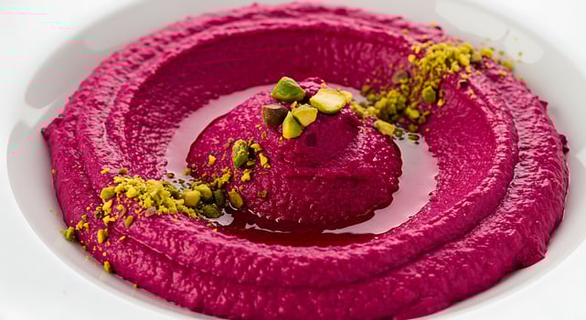 A bowl of beetroot hummus with pistachios photo