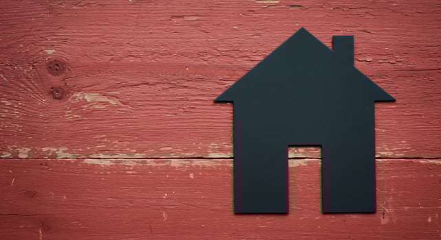 A black house silhouette is on a red wall photo