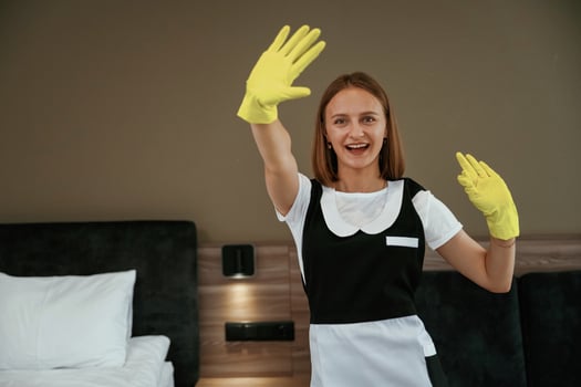 Professional ,occupation, in yellow gloves. Young chambermaid is in hotel room photo