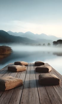 Serene lakeside vista with fog shrouded mountains and inviting pillows on a wooden deck platform photo