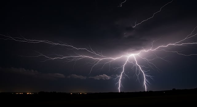 Lightning strikes over a field at night photo