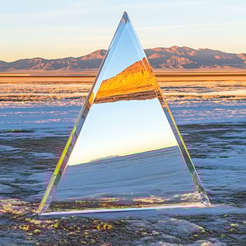 Reflective Glass Pyramid in a Snowy Desert Landscape with Mountains photo