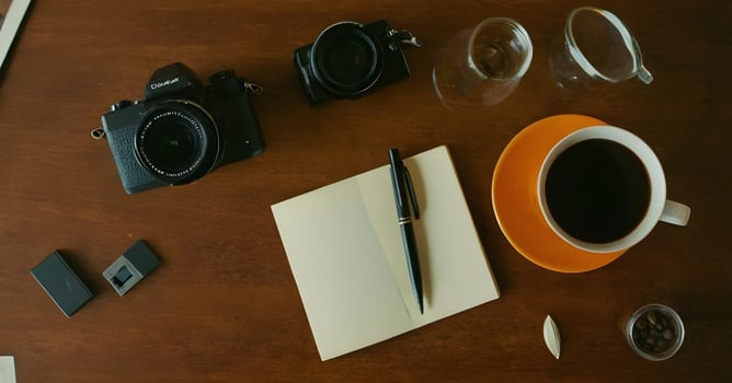 Photographer taking a coffee break at desk organizing photos