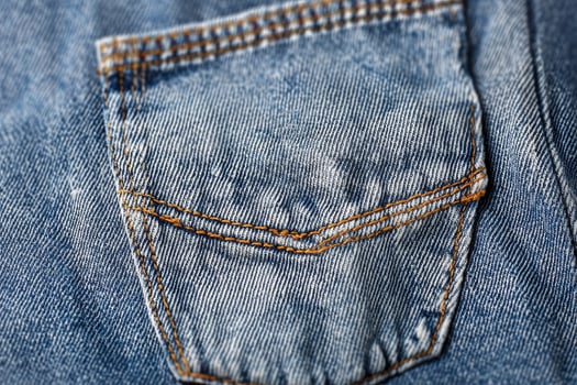 Close-up view of textured denim fabric showcasing intricate pocket details in a vibrant blue hue photo