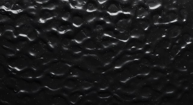 A black surface with some water on it photo