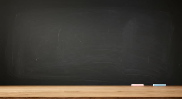A blackboard with chalk on it and a wooden table photo