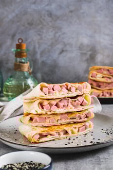 Grilled sandwiches in pita bread with sausage and cheese on a plate vertical view photo